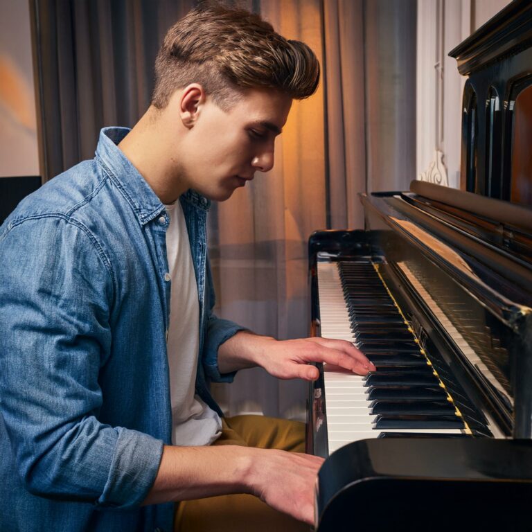 A young man learning the piano chord of A Major